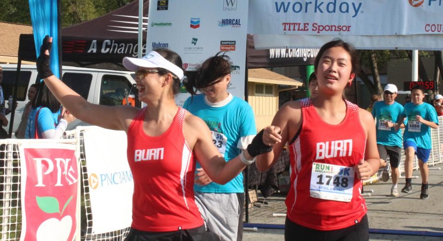 A mother-daughter duo excitedly cross the finish line.