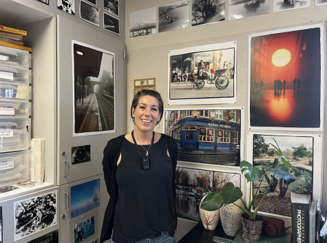 Merilee Fisher stands in front of the pictures she took on various trips. 