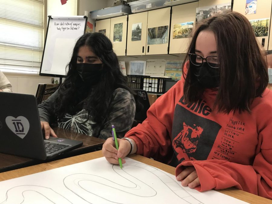 Following the new masking guidelines, Laurel Wall ('24) and Anika Parkhi ('24) complete their work next to each other.