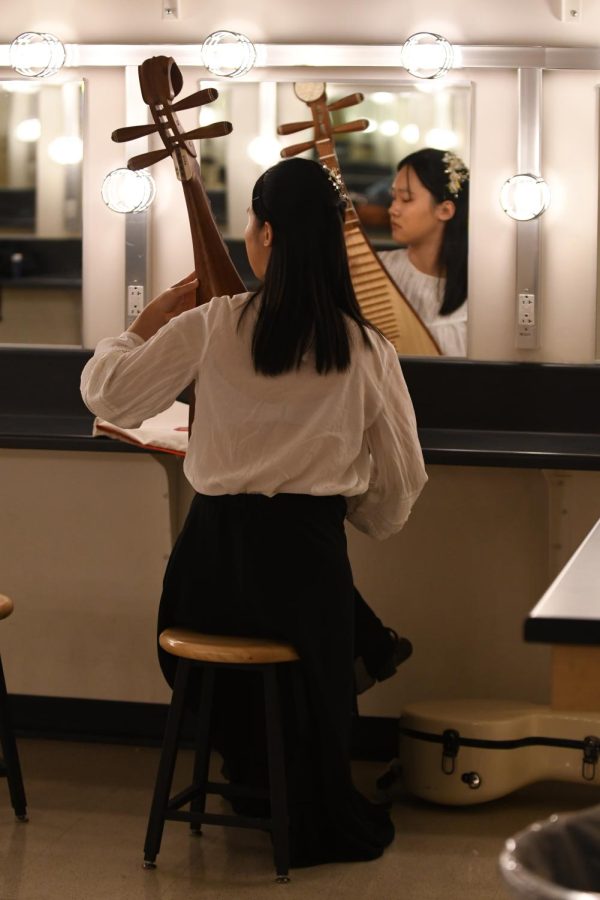 Leyi Lu practices pipa, a traditional Chinese instrument, in the dressing room before the show starts. (Jiawen (Sarah) Yan)