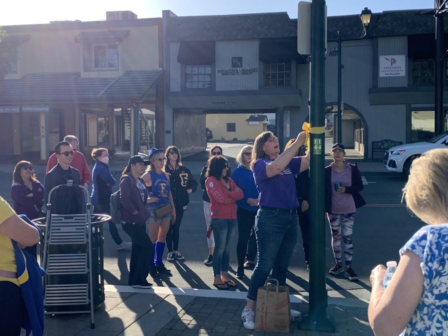 Robin Cruz teaches the group of volunteers how to tie the ribbons to lampposts.