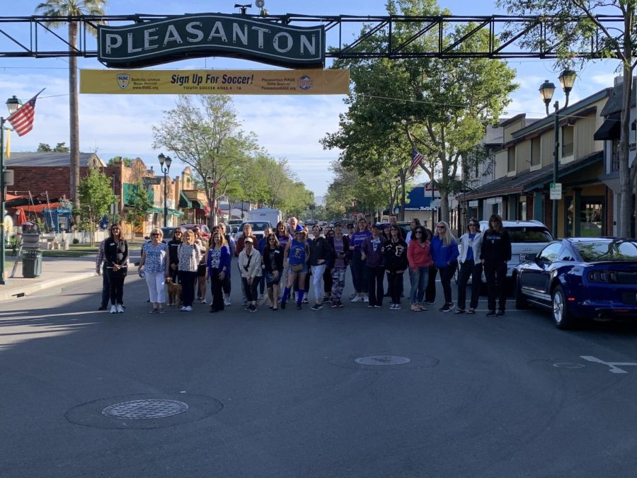 The volunteers all pose together under the Pleasanton sign.