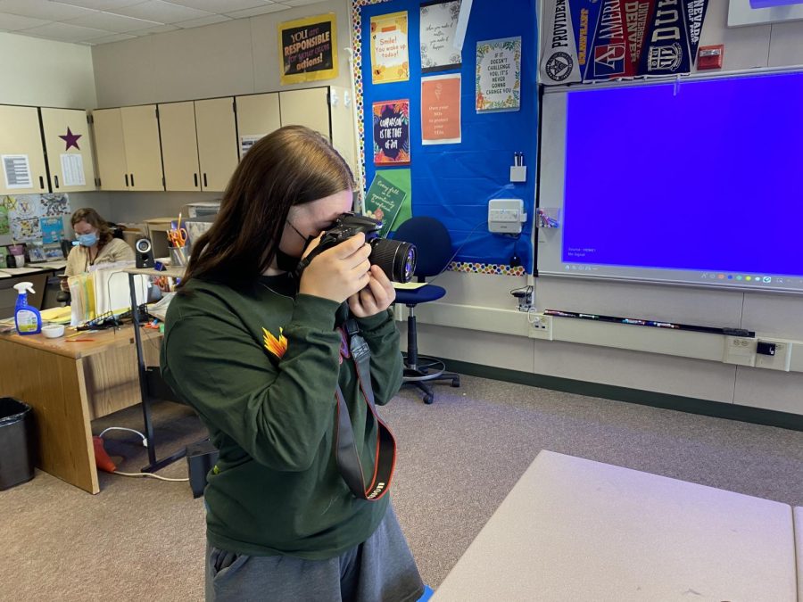 Holly Fletcher ('22) adjusts the camera settings on her camera to get ready to go take photos