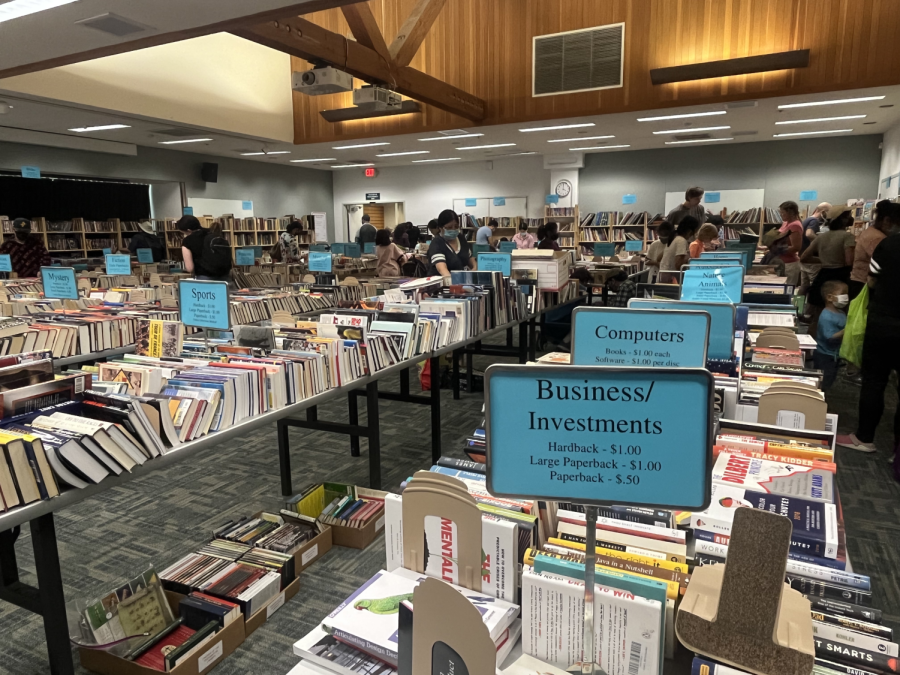 Shoppers browse and peruse books at a cheap price, taking in the atmosphere of a used book sale.