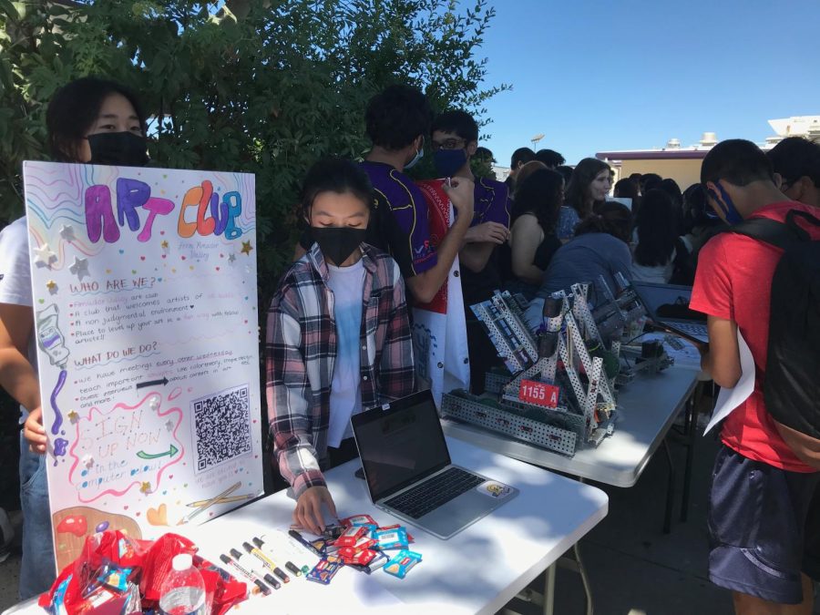 Art Club officers organize their promotional booth and introduce their club to interested students.