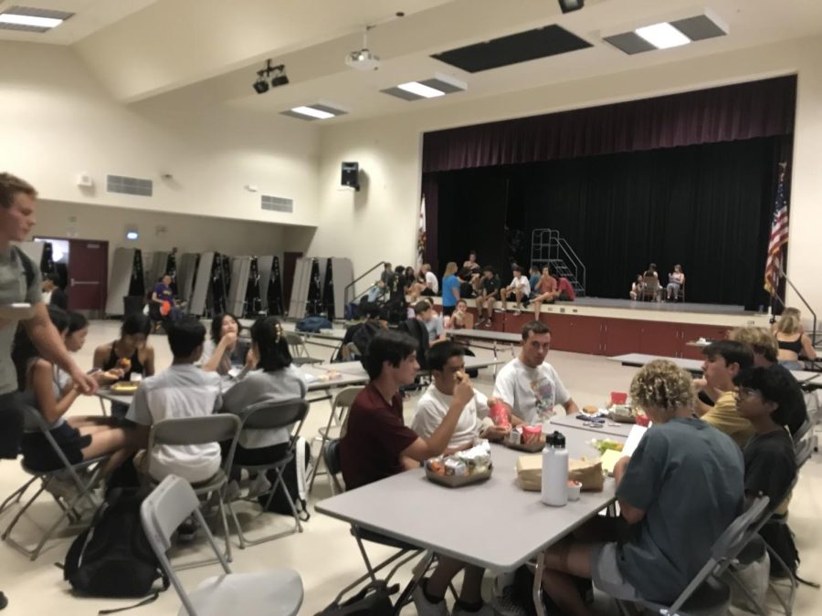 Students try to beat the heat by sitting inside for lunch. 