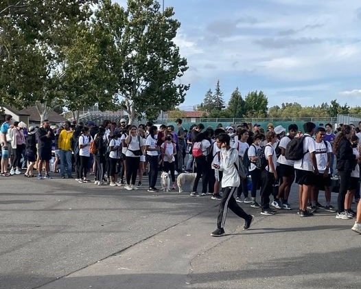 On the blacktop, students wait in line for ice cream.