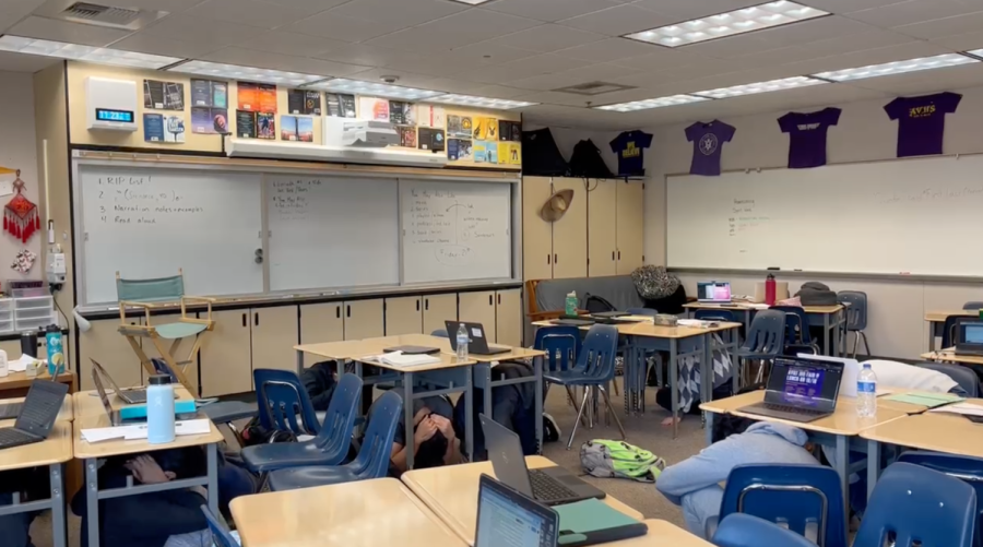Students ducking under their desks during the CA shakeout to practice drop, cover, hold on.
