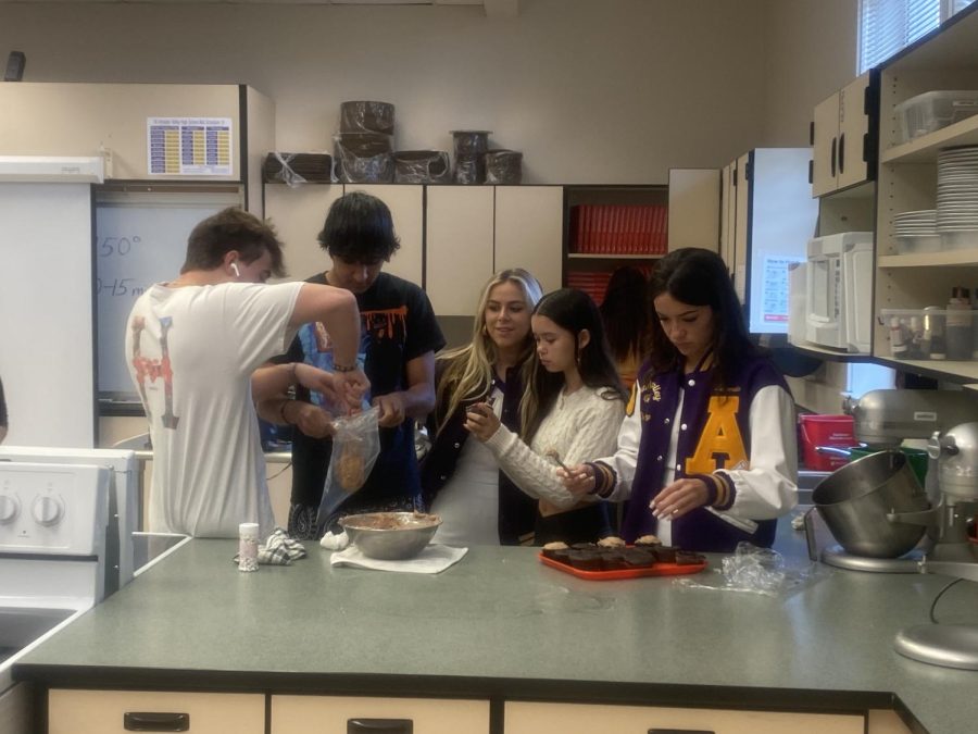 Students prepare their frosting by putting it into a bag. This took teamwork and many helping hands.