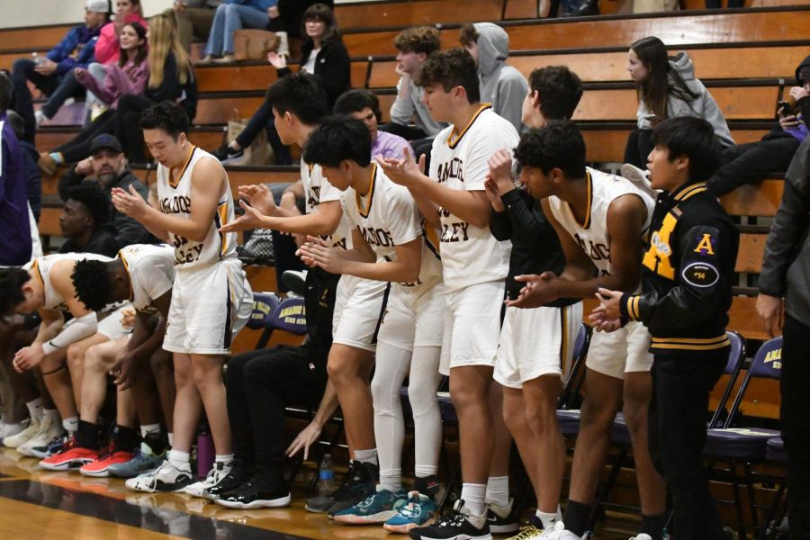 While resting, half of the team cheers on their playing teammates from the bench.