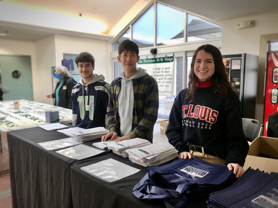 Student volunteers Sydney Queen (24), Bill Situ (23), and Mateo Gable (24) greeted visitors at the events entrance.