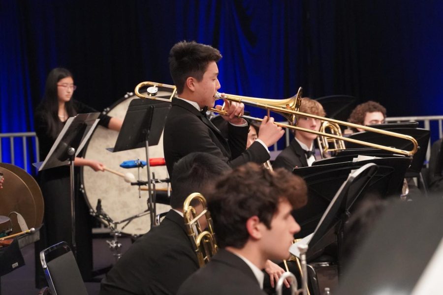 Soloist Jayden Sano (‘24) plays his trombone while looking at his music.