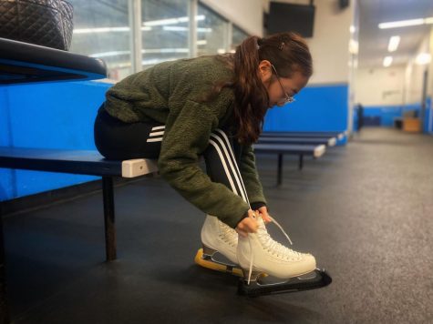 Isabel Jung (25) laces up her skates for a 5:30 A.M. practice at the rink. 