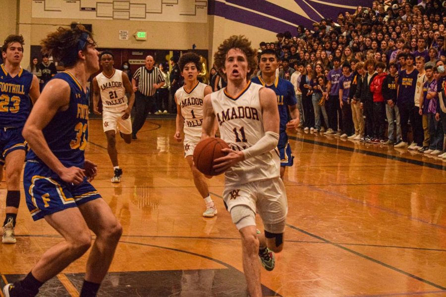 Colton Cash (#11) prepares to go up for a contested layup as the crowd watches in anticipation.