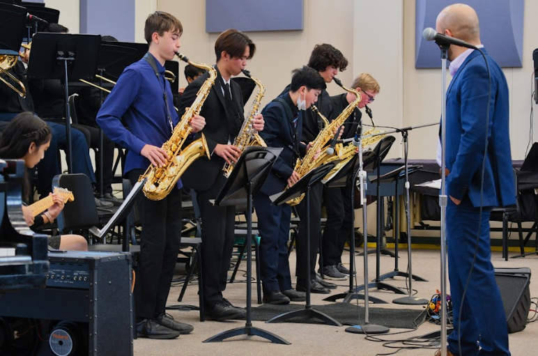The saxophone choir of Jazz Workshop, featuring Dashell Finn (‘25) and Thomas Iordache (‘26) on tenor saxophone, Bruce Lin (‘26) and Tyler On (‘26), and Samuel Barnes (‘26) on baritone saxophone, performs a soli during their performance. 