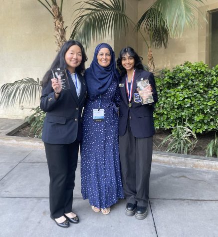 Co-Presidents Andrea Yang (23) and Pallavi Shankar (23) pose for a picture with DECA advisor Marjan Akrami after receiving glass awards for placing in the top three.