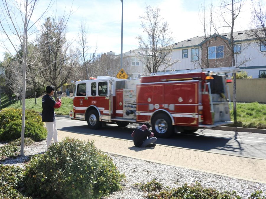 Video production crew Srikar Pasala (24) and Amit Krishna (24) film a firetruck arriving on the scene.