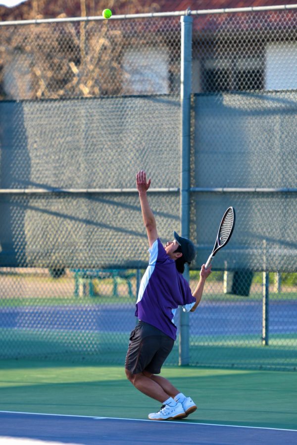 Bryan Park tosses the ball up high for a serve.
