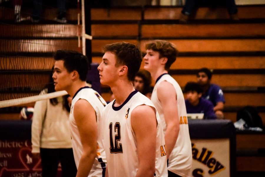 #5 Ryan Yu (‘24), #12 Max Riter (‘25), and Bryce Nohava watch as the opponent prepares to serve. 
