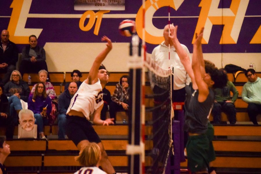 Nate Clinton jumps high to send a ball flying over the opposing blockers to score a point.
