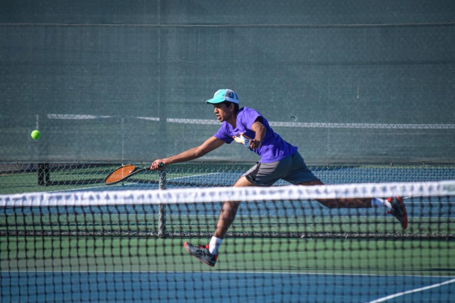 Anuraag Aravindan takes a large stride to reach a serve from his opponent.
