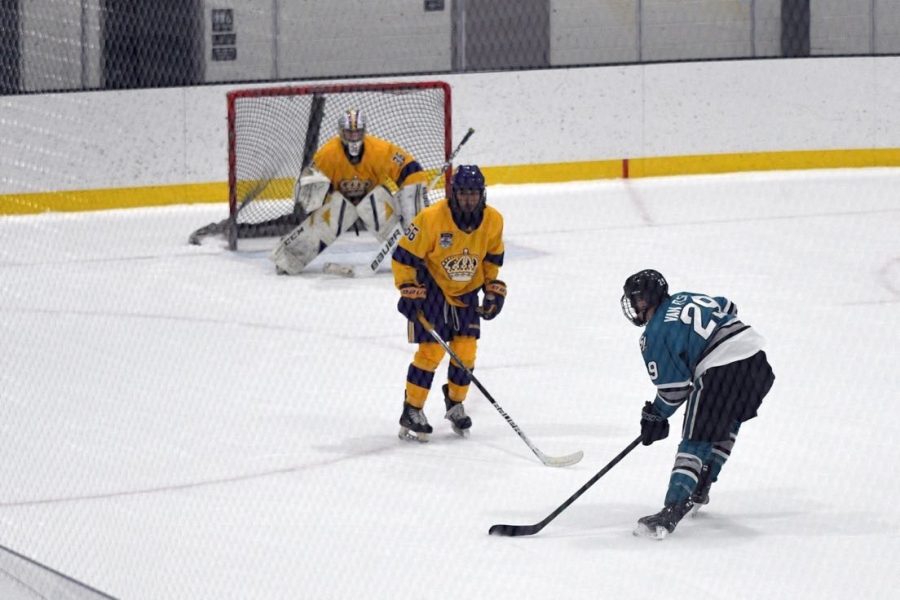 DJ Van Fleet ('24) [in blue] takes a shot at goal during a tournament in Detroit last summer. 