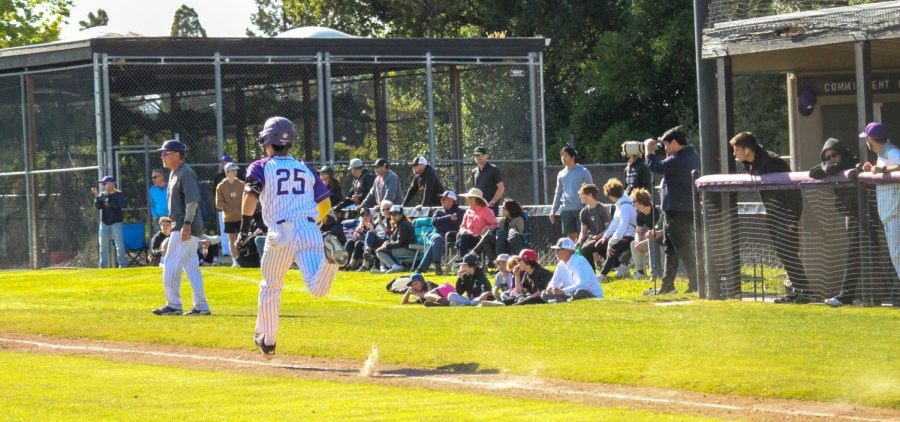 Evan Berry (‘24) quickly runs toward the first base as the crowd watches intently. 