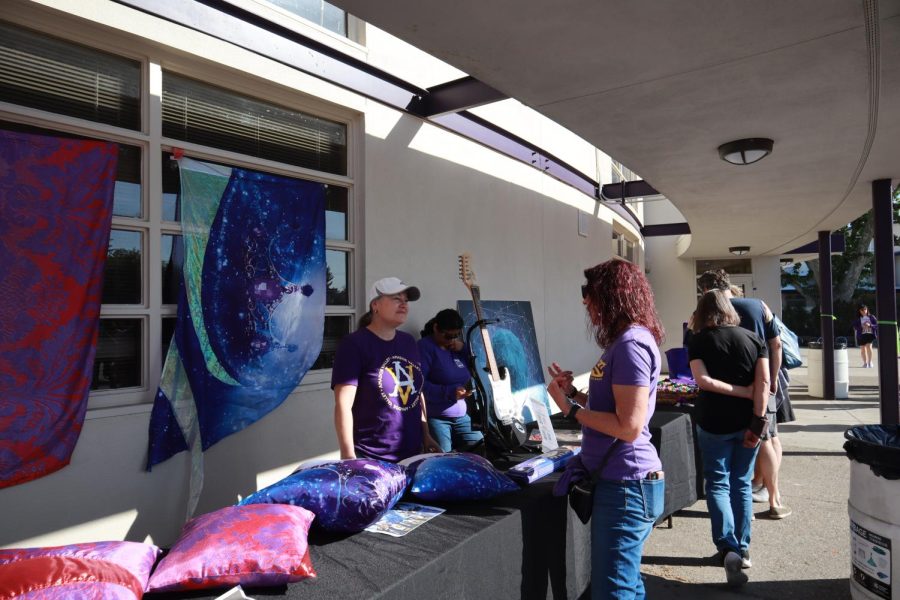 Parent volunteer helps auction off hand-sewn pillowcases by Danica Howard ('23) made by old Colorguard silks.