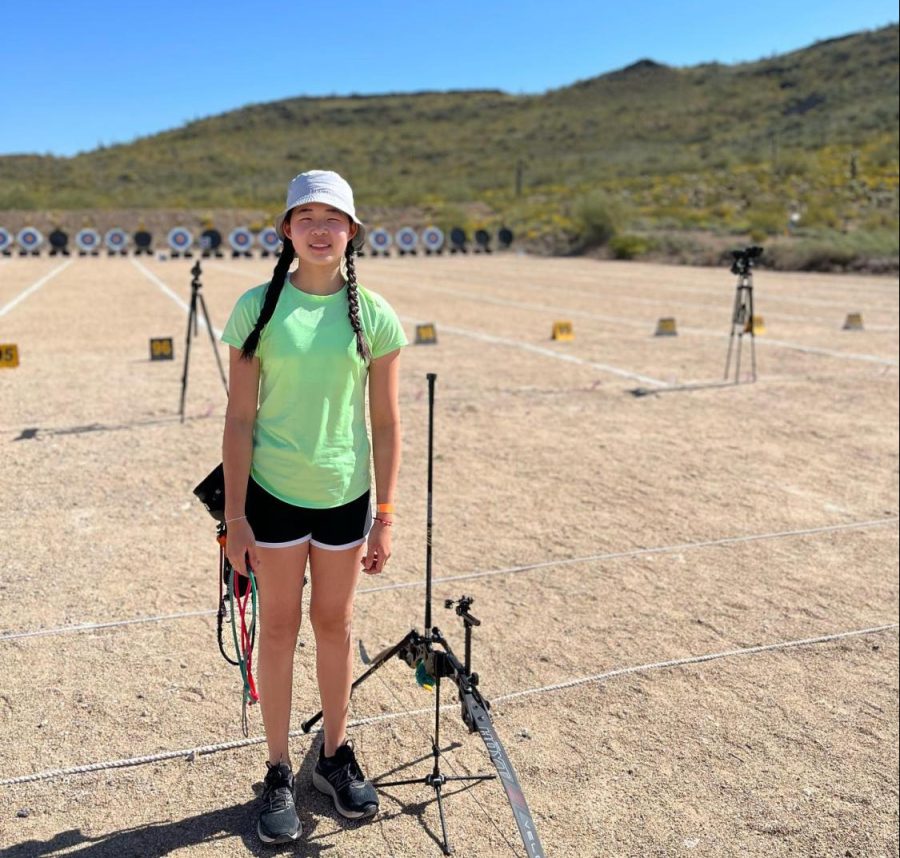 Jinghan Li (‘26) smiles for the camera with her archery equipment at practice. (Photo provided by Jinghan Li)