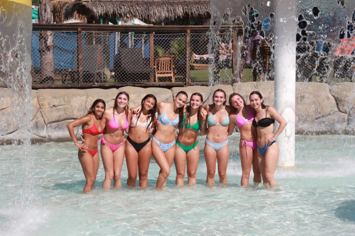 A group of seniors pose for a photo to capture a memory amidst the waves of a pool during the Senior Picnic.