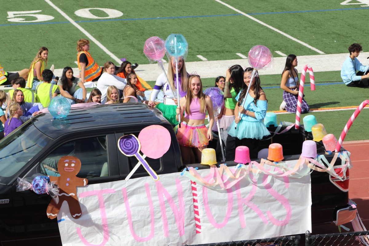 Junior stand upon their float decorated in pink and blue candies. 