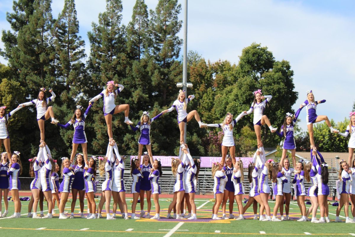 Hand in hand, cheerleaders hold each other up during their routine. 