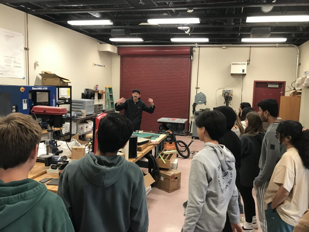In the engineering workshop room, teacher Eric Ra explains to freshmen the technology used in the engineering curriculum. 