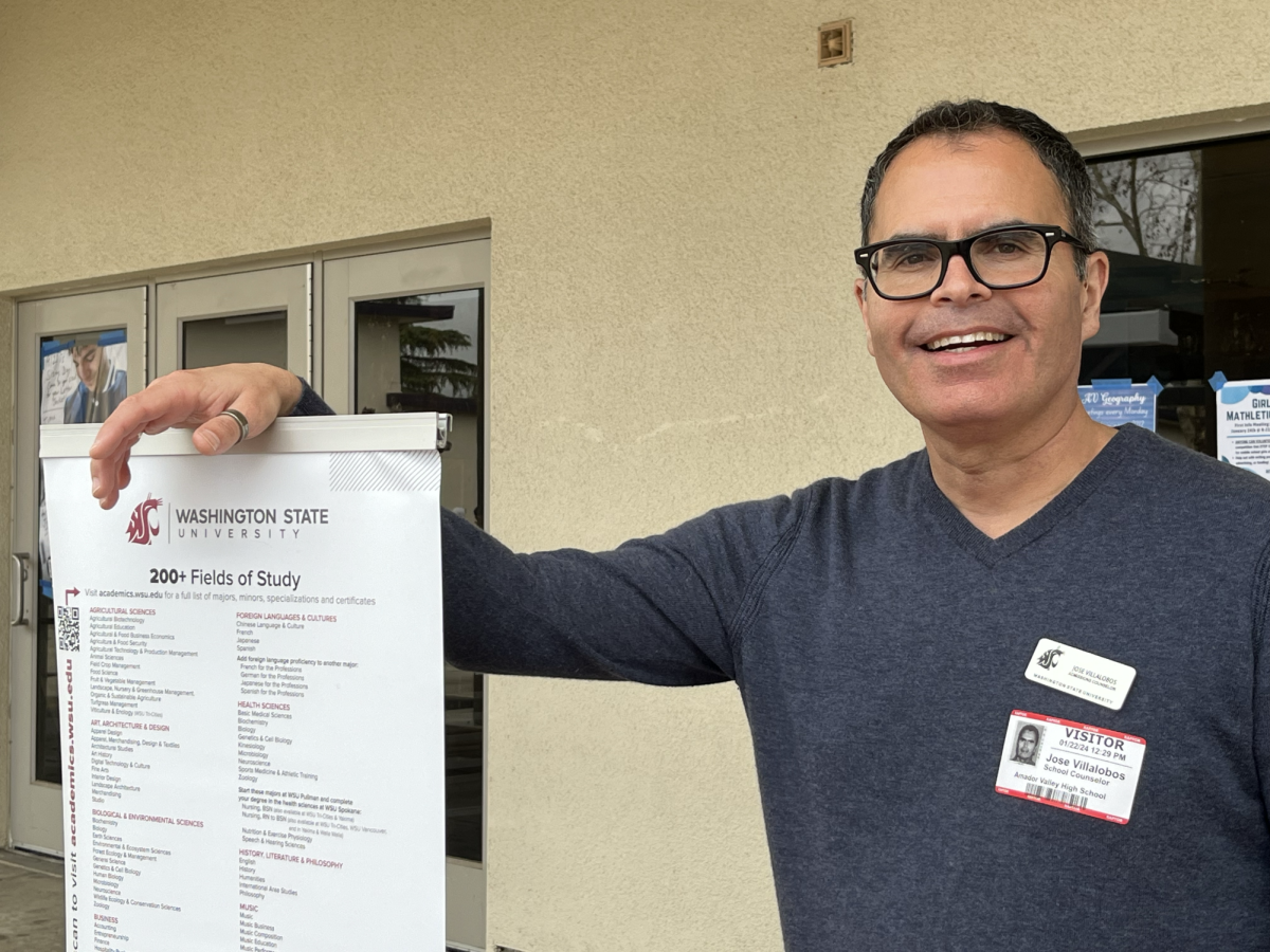 Admissions counselor Jose Villalobos poses with his promotional booth.