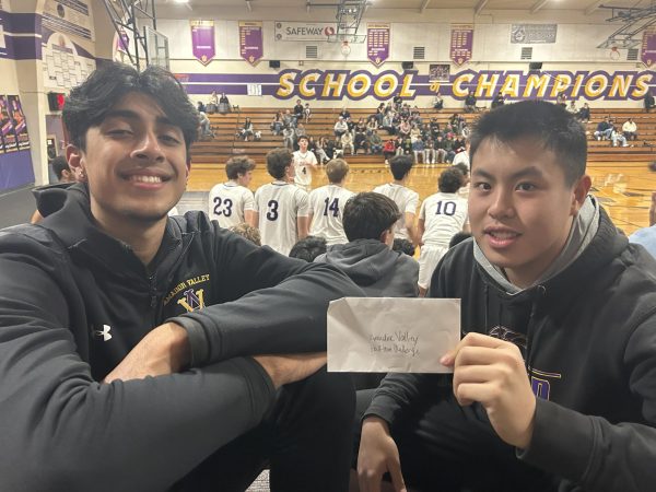 Christopher Hoang (26) holds his $500 envelope with rebounding partner Rayyan Shah (26) after winning the half-time competition.