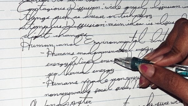 A student reads over a page written in all cursive.