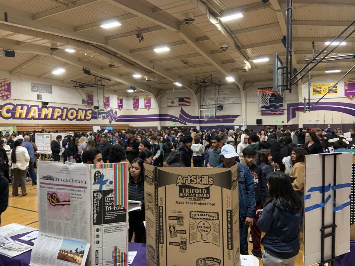 Each table was covered in posters, props, and promotional materials, while hundreds of curious students walked the rows. 