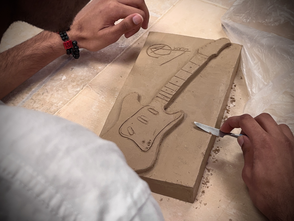 A student puts the finishing touch on his project with a knife.