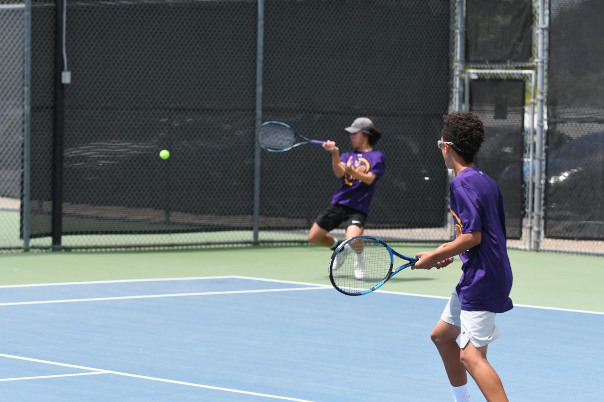 Parkinson-Lubold watches as his partner Fan Jia (26) hits a forehand return.
