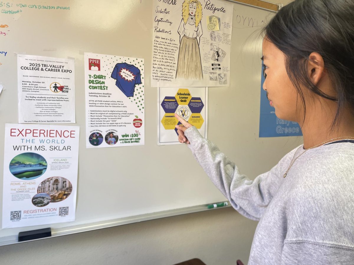 Sarina Liu ('27) points to the PPIE T-Shirt contest poster posted all around campus.