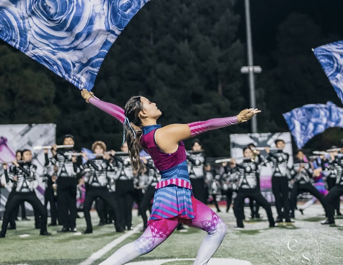 Kiki Yasui ('26) reaches forward with a swing flag, adding drama and flair to the performance.