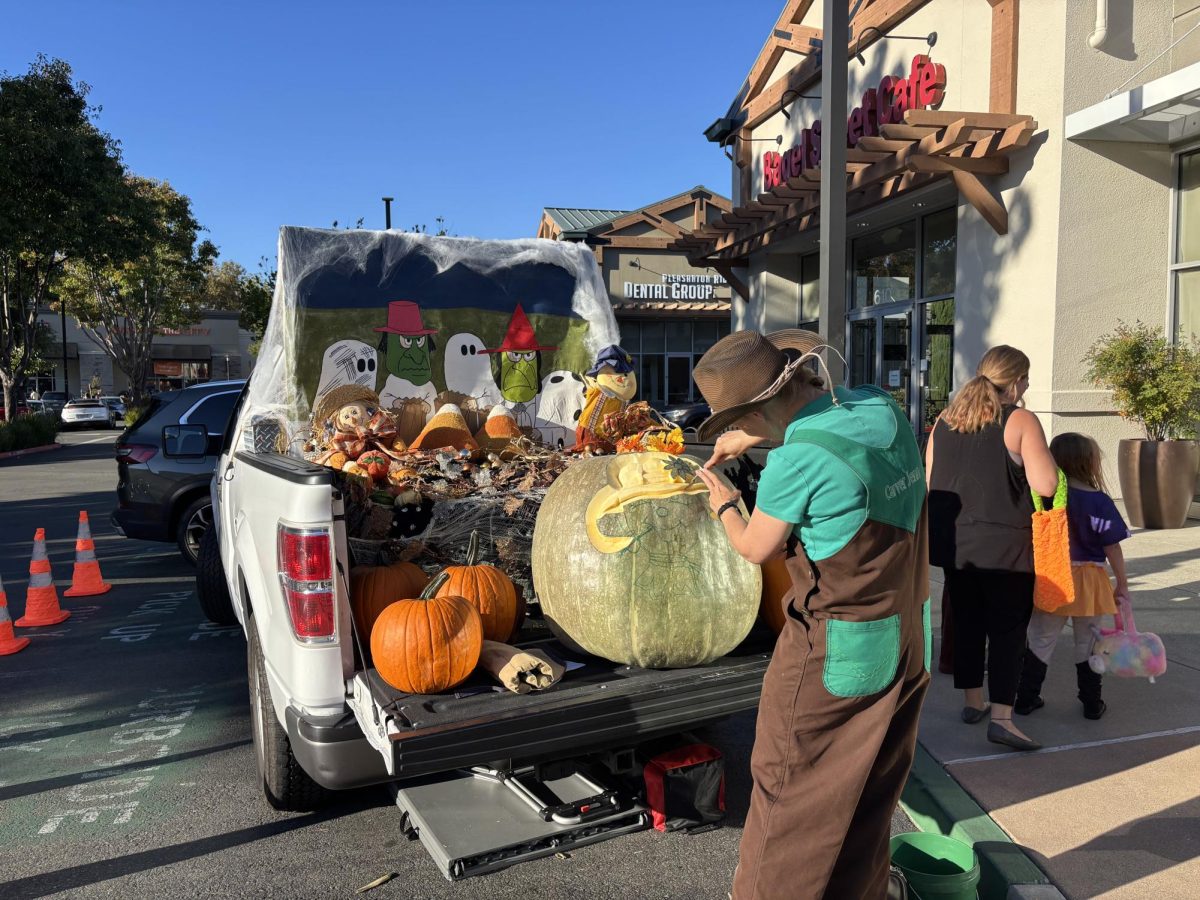 Pumpkin carver demonstrates how to carve an intricate design at Pleasanton Gateway Shopping Center's Halloween event.