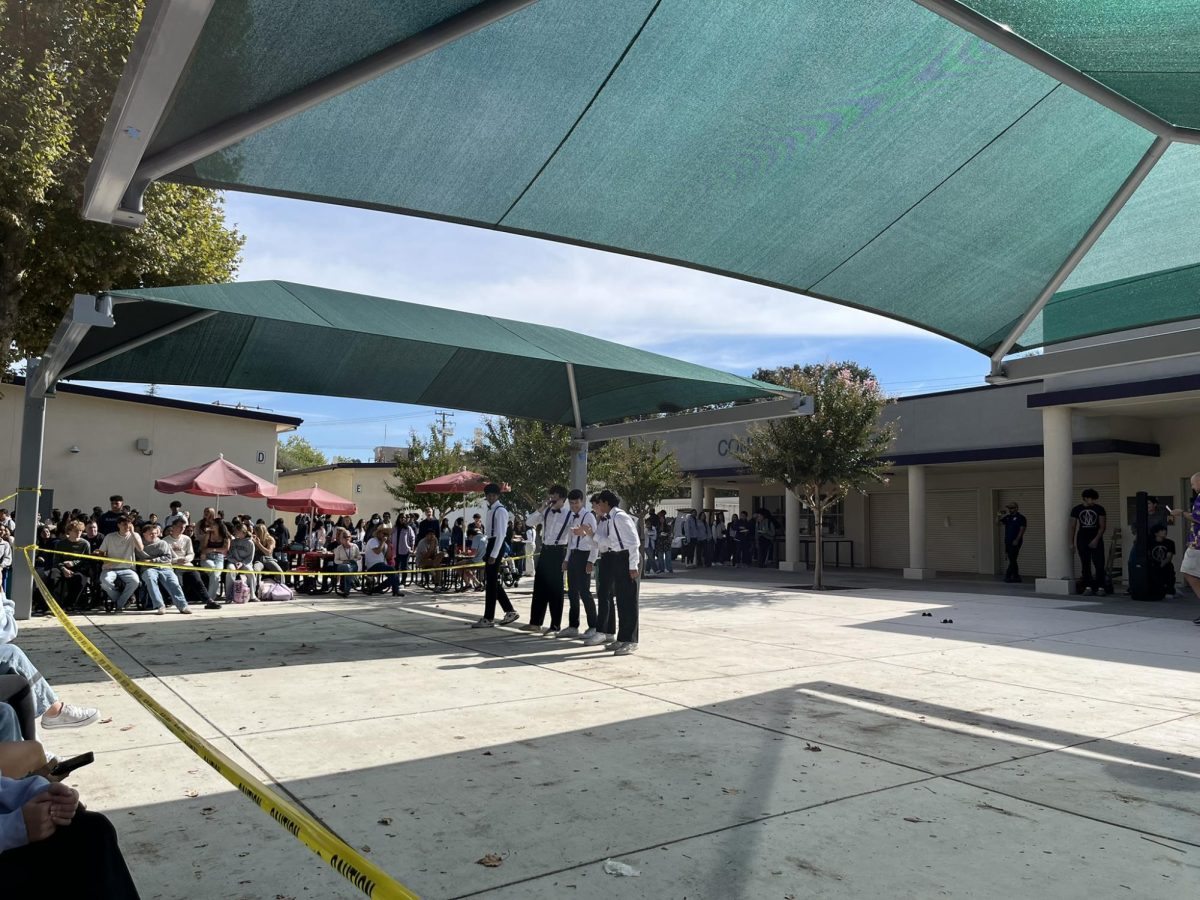 Mr. Amador members line up in front of a bustling lunch crowd in the quad, ready to perform.