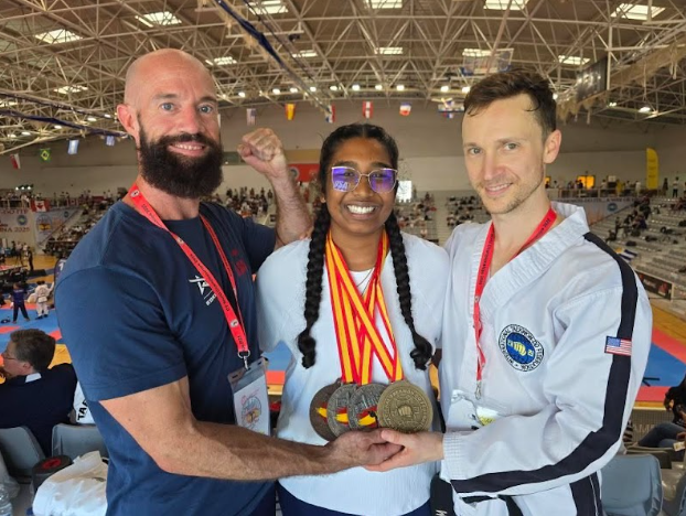 Apoorvaa Muruganathan ('27) poses with her medals and her coaches.