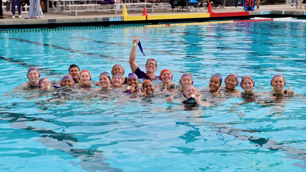 Head Coach Drake Southern jumped into the pool alongside the team following their victory. They clutch their medals proudly. 