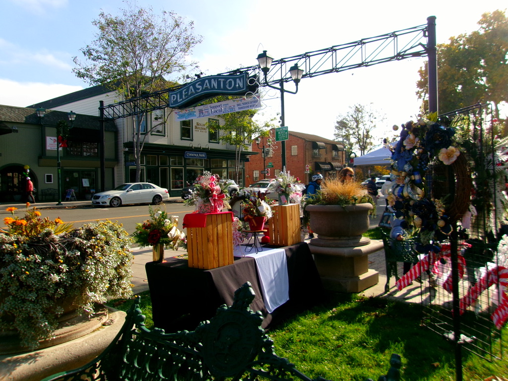 As customers bustle around the Market, the afternoon sun and the Pleasanton sign offers a warm welcome to visitors and locals alike.