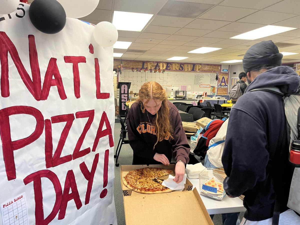 Leadership student Rachel Thalman ('26) passes out pizza to the winners of Pizza Bingo.