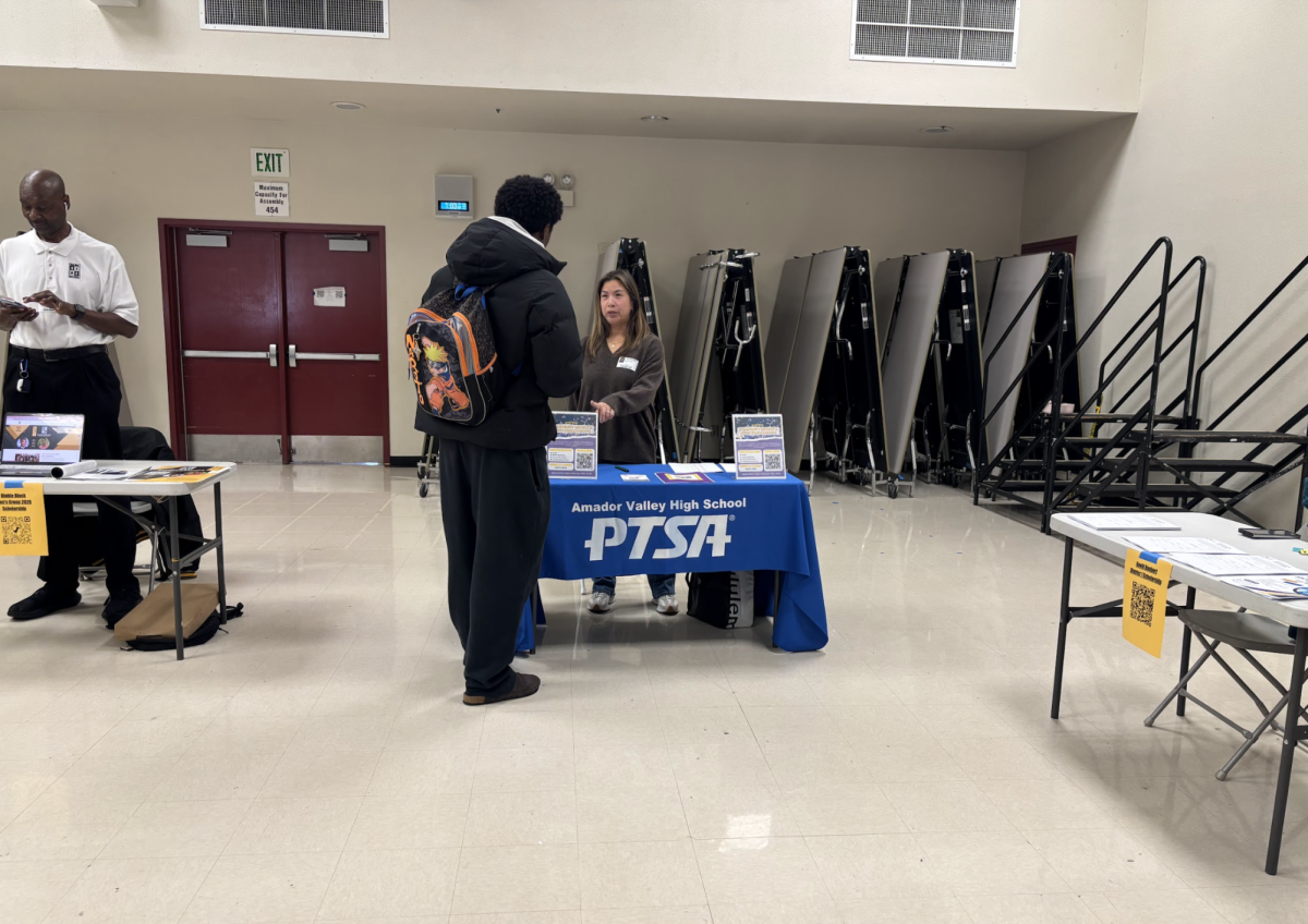PTSA Staff member Melissa Toh informs AVHS student Biruk Meena ('26) at the PTSA informational booth. 