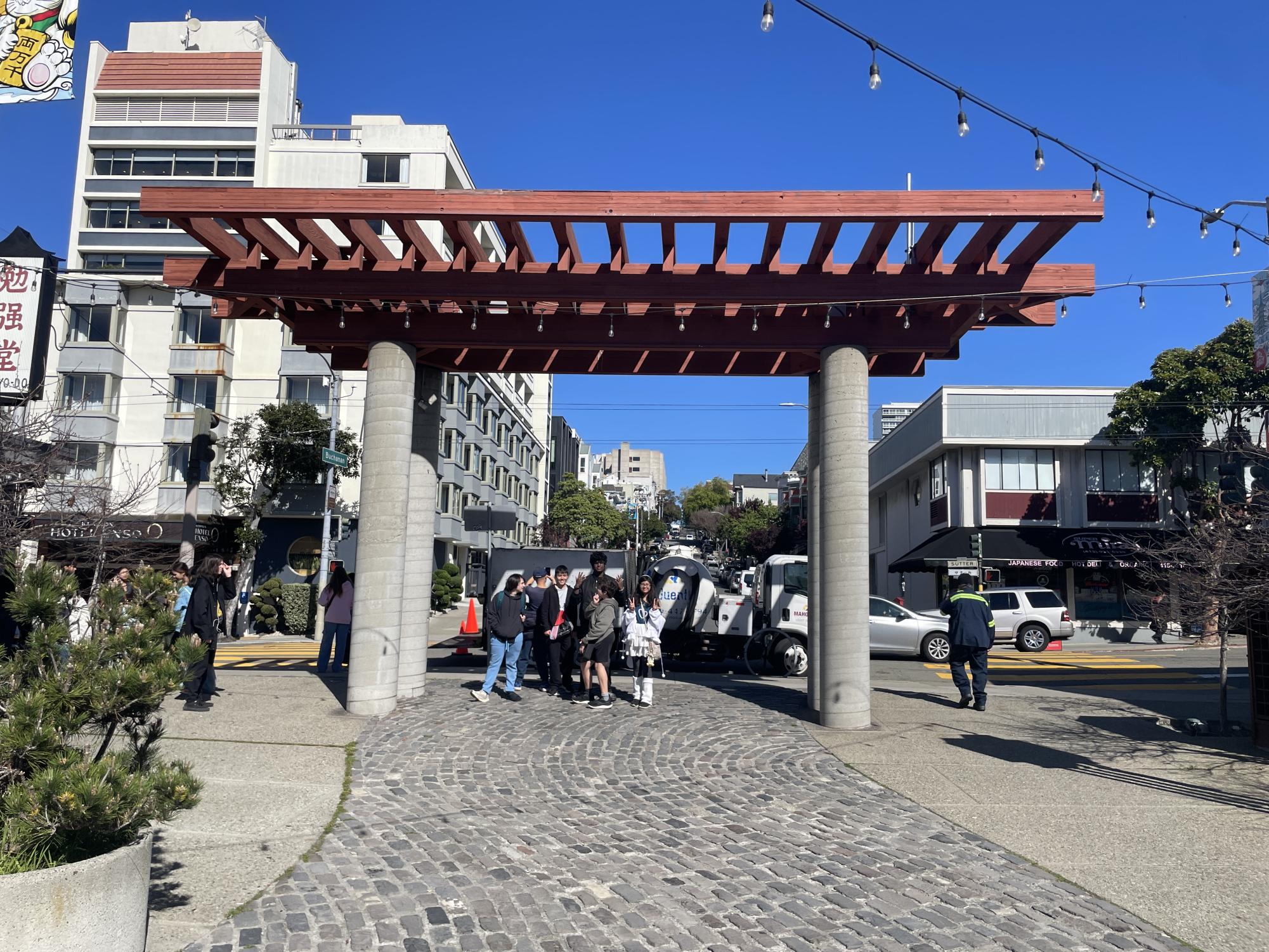 Japanese students underneath an arch inspired by the architecture of traditional Japanese shrines.