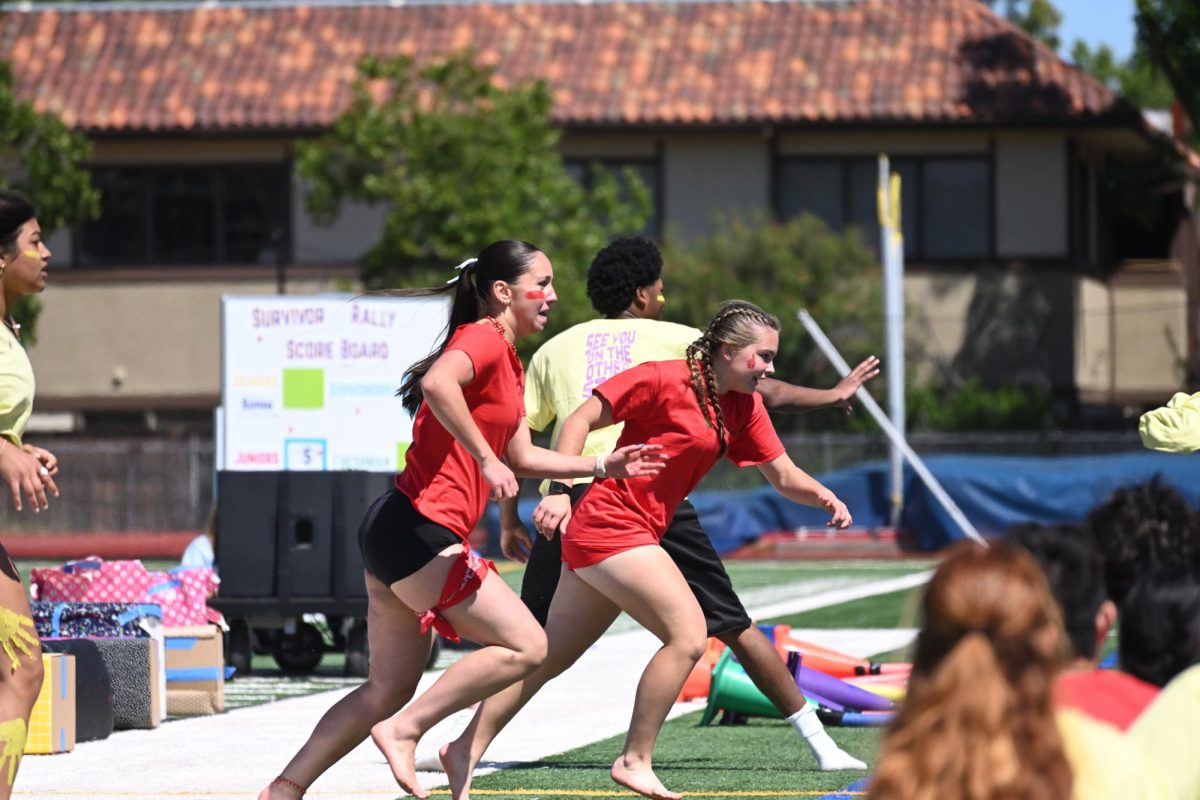 Abby Hiller ('27) and Charlotte Merrill ('27) run towards the audience, desperate to find the required items to complete the scavenger hunt round before the seniors.
